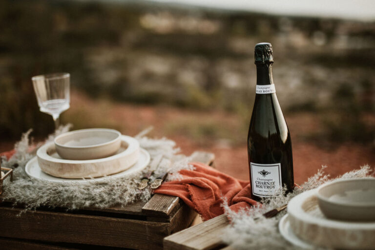 Bouteille de Champagne Charnay Boutroy et coupe posées sur une table en bois